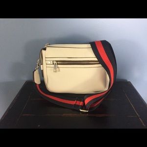 White purse with striped accents.